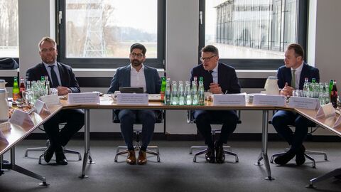 Ministerpräsident Boris Rhein und die Teilnehmerinnen und Teilnehmer des „Runden Tischs Kernfusion“ sitzen in einem zu einer Konferenz positioniert.