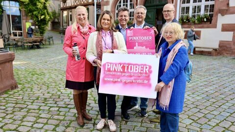 Mehrere Personen stehen zusammen und halten ein Plakat in den Händen